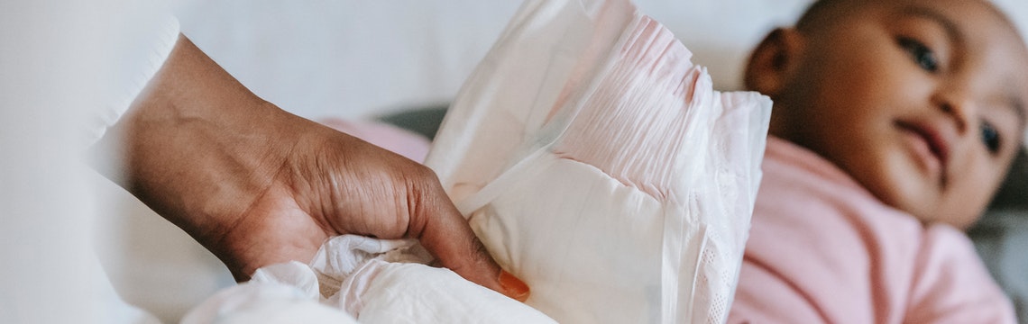 Baby getting diaper changed, hand holding diaper